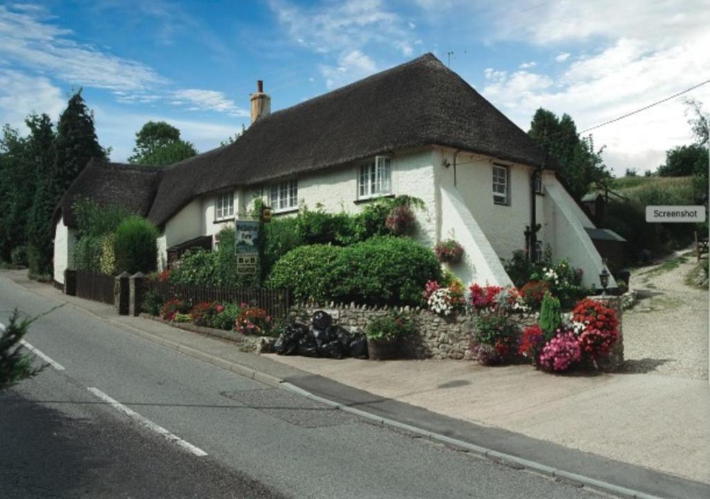 uma casa branca com flores à frente em Wellington Farm Devon near Heritage Coast beaches & AOBN- dog friendly em Honiton