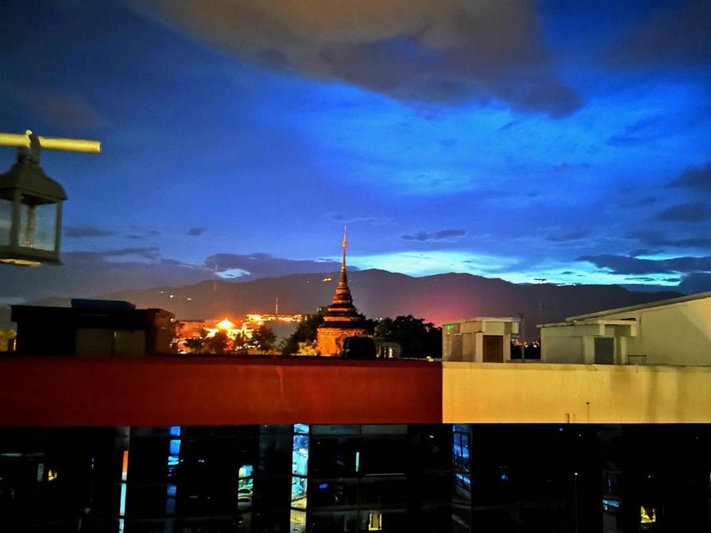 vistas a una pagoda en una ciudad por la noche en Newnormal Hotel, en Chiang Mai