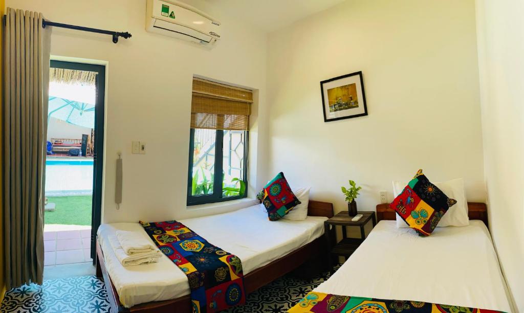 Postel nebo postele na pokoji v ubytování Wanderlust - Beach Side Hoi An