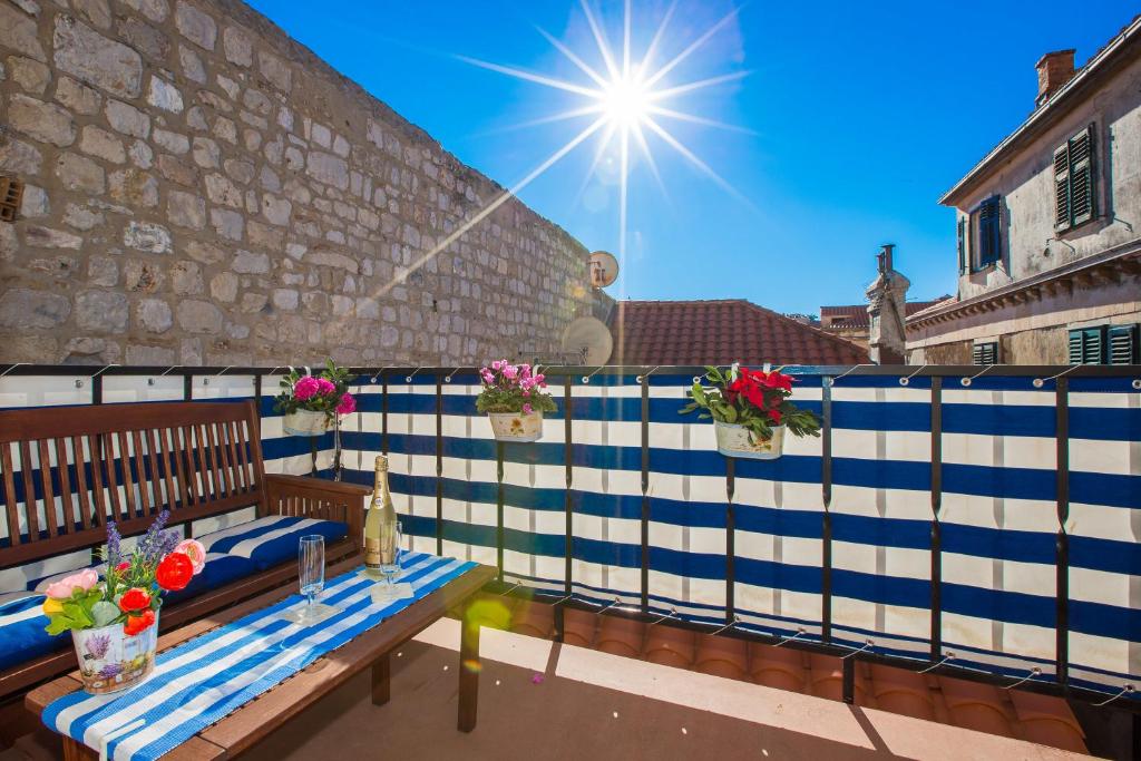 a patio with benches and flowers on a wall at Old Town Apartment Paulina in Dubrovnik