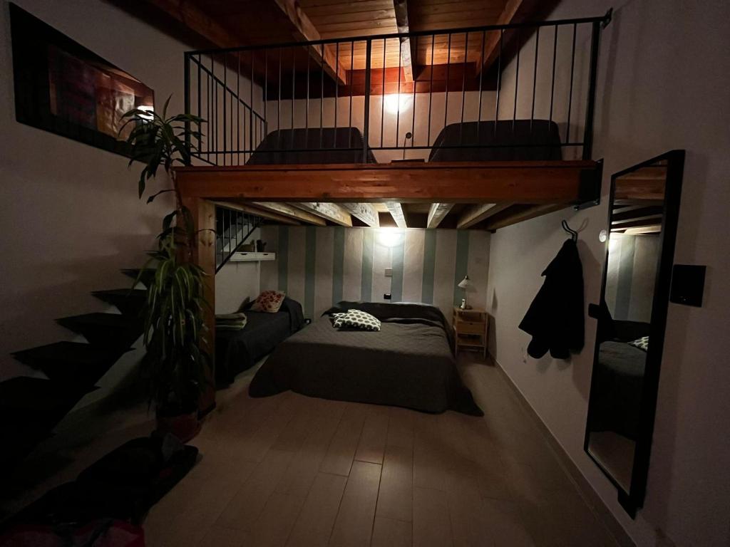 Un dormitorio con una cama elevada y una escalera en B&B Cascina Bedria, en Ivrea