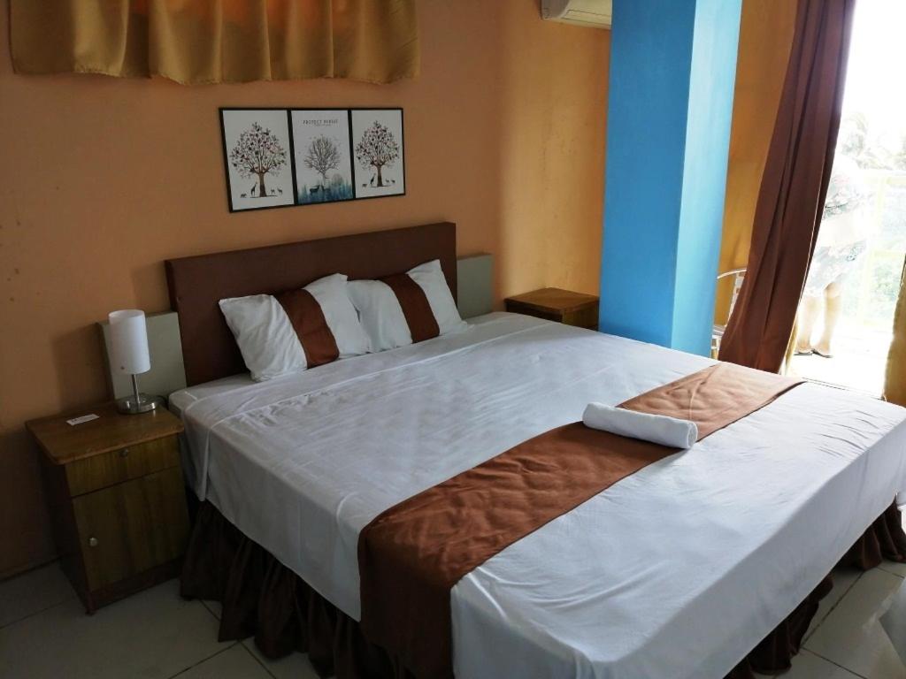 a bedroom with a large bed and a window at Hypertek Guesthouse in Grand Baie