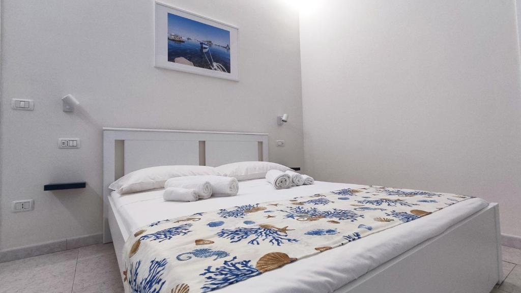 een slaapkamer met een bed met een blauwe en witte sprei bij Marricrio House in Catania