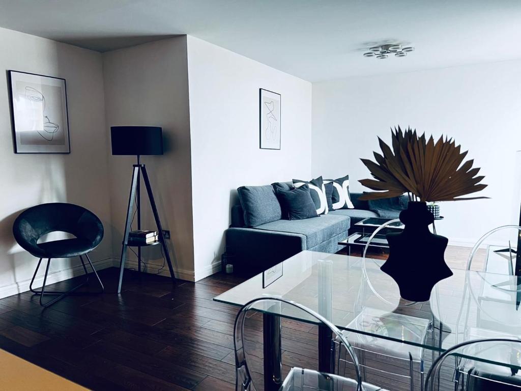 a living room with a couch and a glass table at 2 Bedroom Penthouse Birmingham in Birmingham