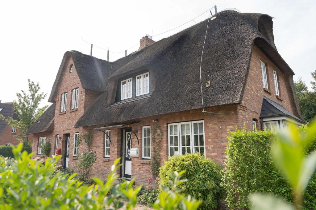 a large brick house with a thatched roof at Friesenliebe in Borgsum