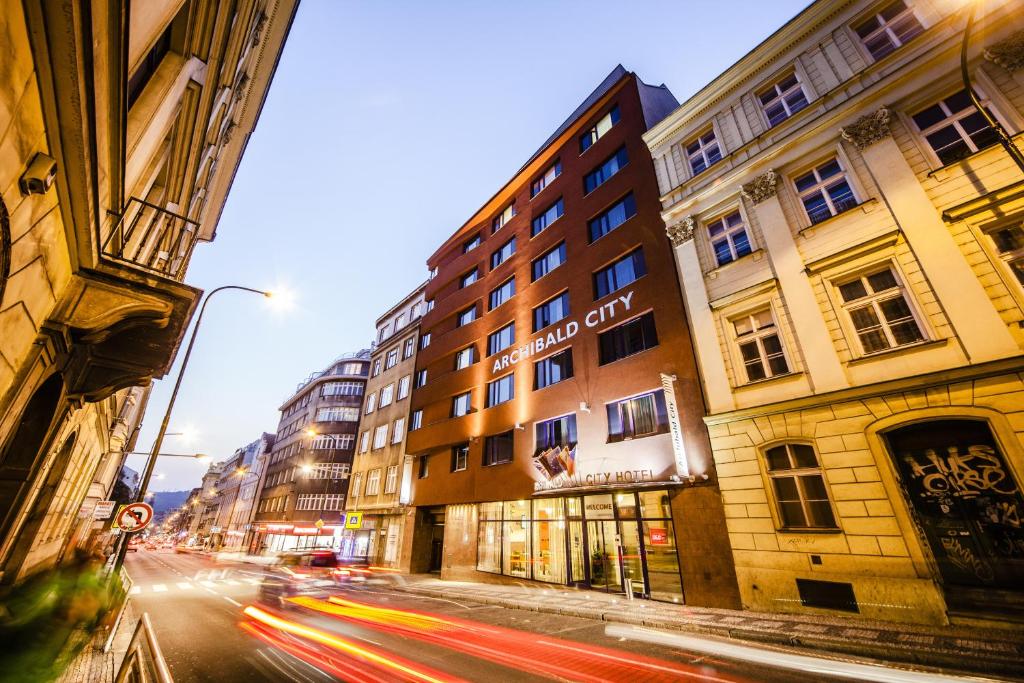 eine belebte Stadtstraße mit Gebäuden und Autos in der Unterkunft Archibald City in Prag