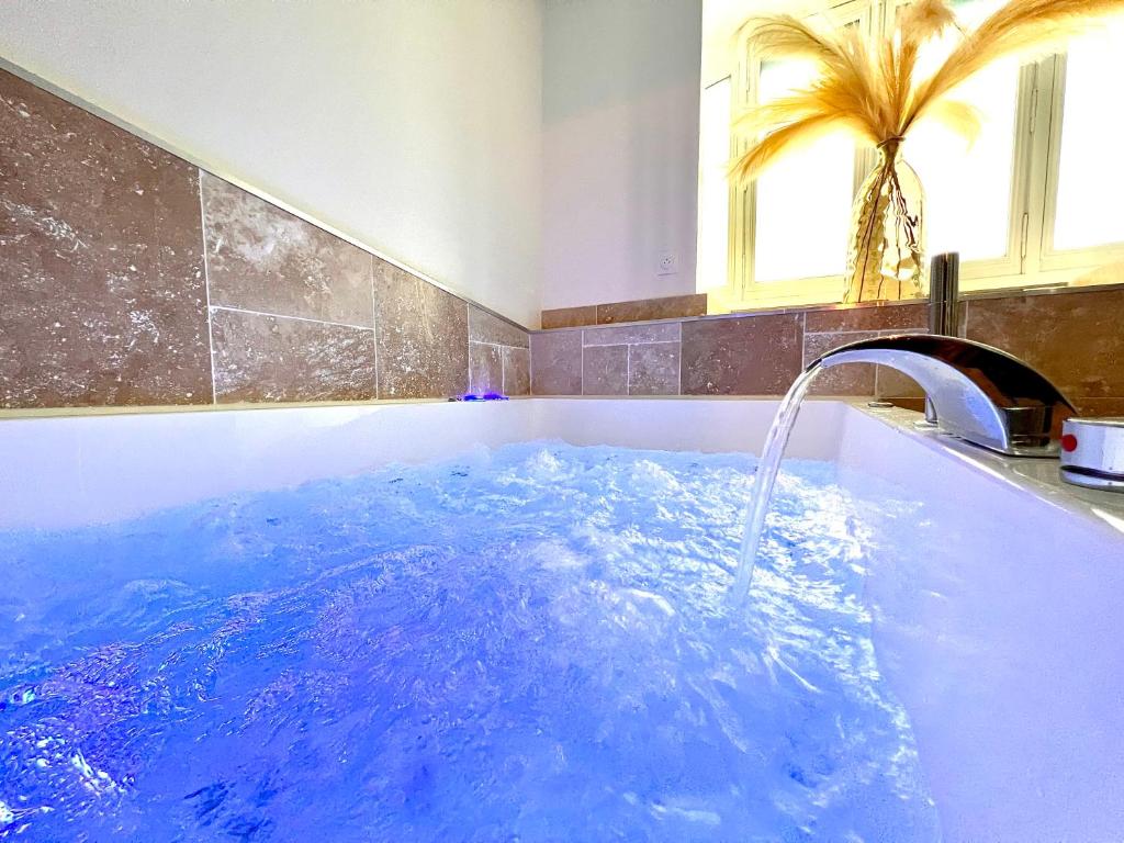a jacuzzi tub with a water fountain at Love Room Secrète Les Petits Plaisirs in Angers