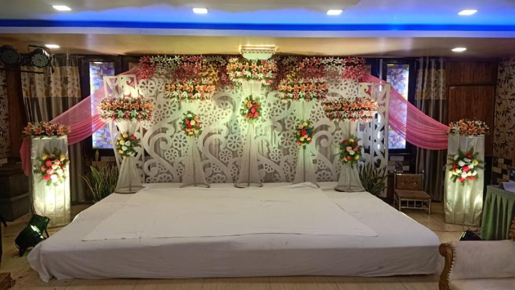 a large bed in a room with flowers on it at Hotel Vilas, Prayagraj in Allahābād