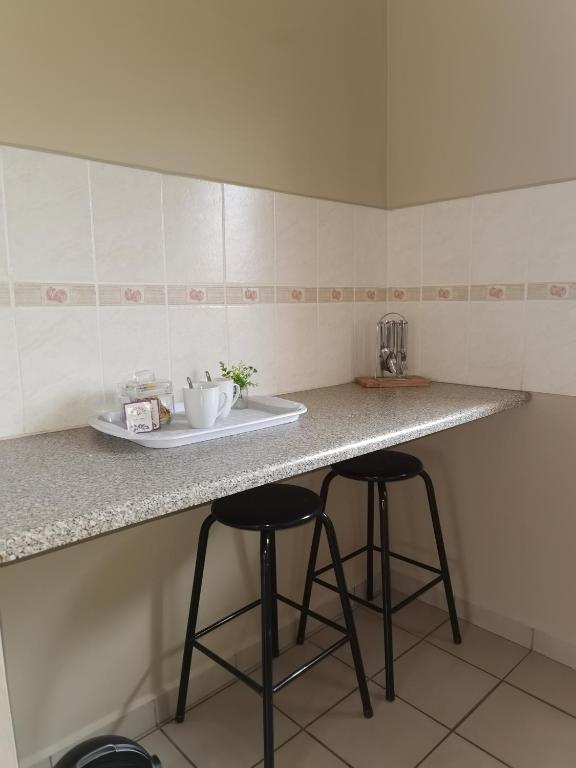 una cucina con 2 sgabelli e bancone di At Home BB a Estcourt