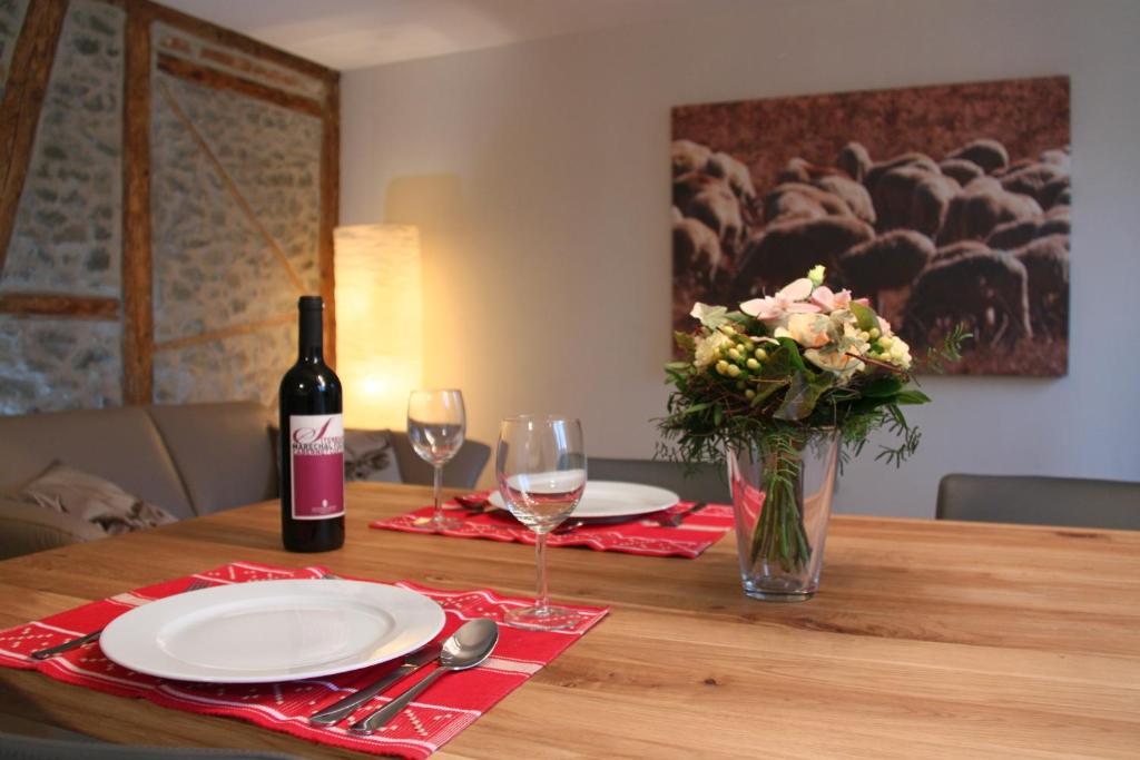 a table with a bottle of wine and a vase of flowers at Easy-Living Apartments Lindenstrasse 21 in Lucerne