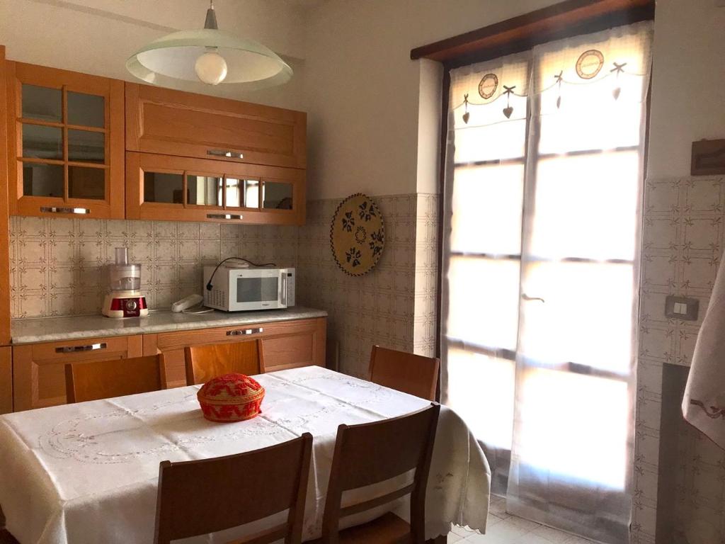 cocina con mesa y mantel blanco en Casa Mariano IV (IUN Q8167), en Oristano