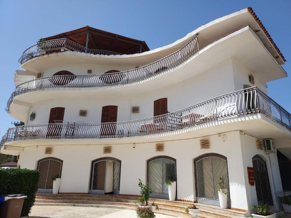 ein großes weißes Gebäude mit Balkon oben in der Unterkunft Arenella Beach Rooms in Arenella