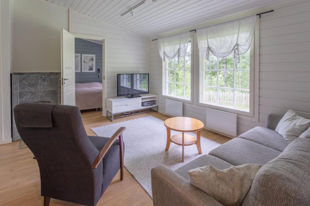 a living room with a couch and a tv at Lomaperkkiö Cottages in Kajaani