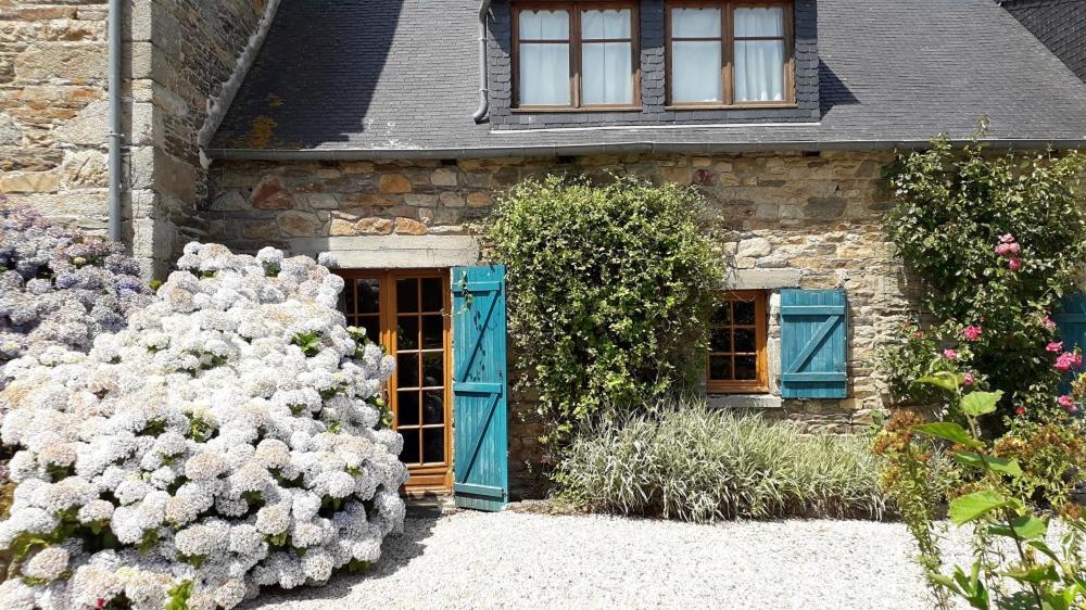 ein Steinhaus mit blauen Türen und Blumen in der Unterkunft Ti Dour - Gîte de charme à la campagne - côte de granit rose in Bégard
