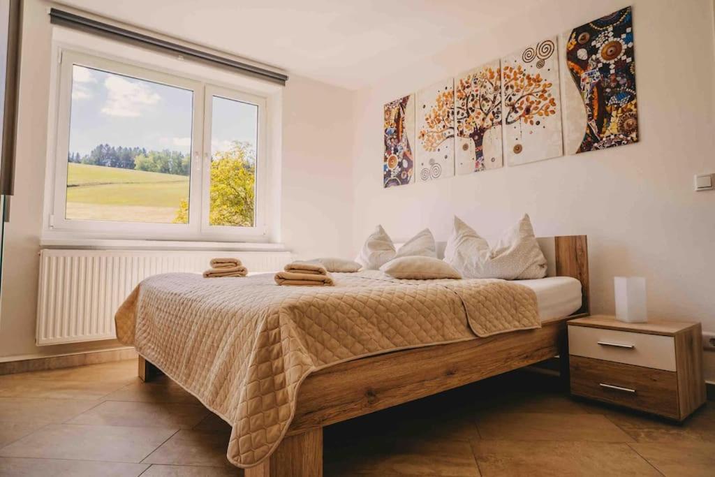 - une chambre avec un grand lit et une fenêtre dans l'établissement Franzis Feriendomizil im Herzgebirge am Skihang, à Auerbach