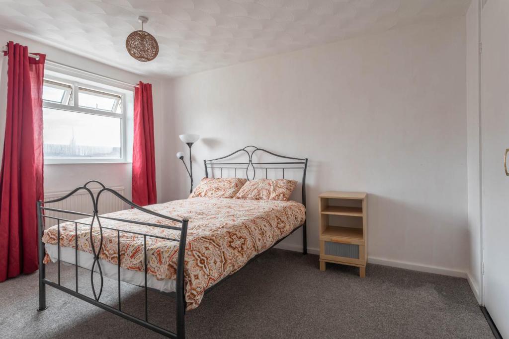 a bedroom with a bed with red curtains and a window at 10 MIN to City Centre R2 in Beeston Hill