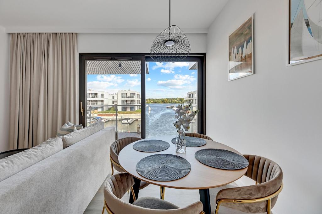 a living room with a table and a couch at Sol Marina - Pool, SPA, Wellness, Riverview & Parking by Downtown Apartments in Wiślinka