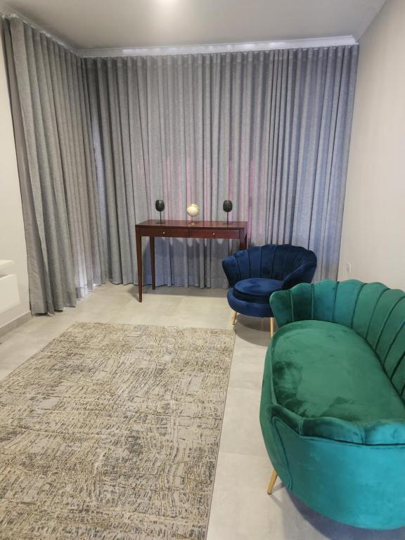 ein Wohnzimmer mit einem Sofa, einem Stuhl und einem Tisch in der Unterkunft Sarona city Habitat Alpha apartments C202 Gaborone in Gaborone