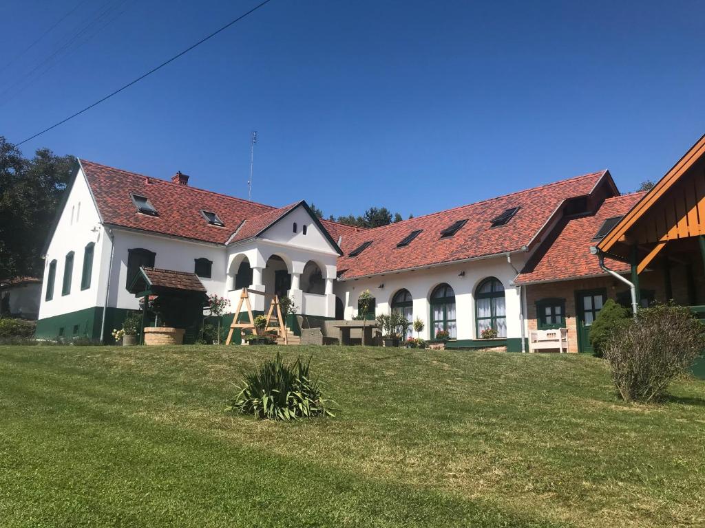 un gran edificio blanco con techo rojo en Fény-Szer Vendégház Őrség, en Szentgotthárd