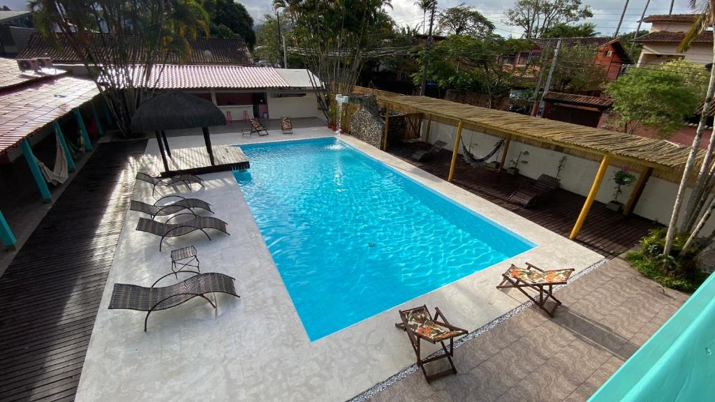 uma vista sobre uma piscina com cadeiras e um guarda-sol em Pousada Maria Felipa Ilhabela em Ilhabela