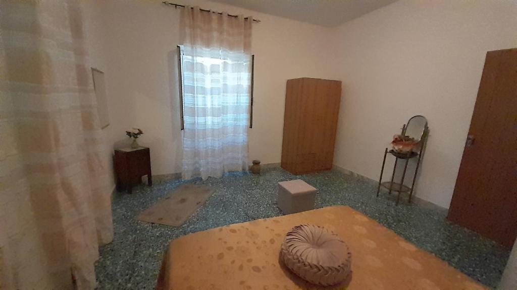 Zimmer mit einem Tisch und einem Fenster in der Unterkunft Casa Concetta in Marina di Fuscaldo