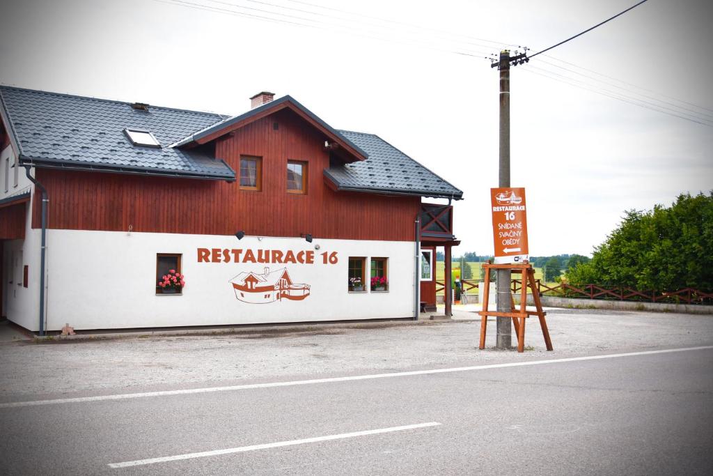 a red and white building with a sign on the side of it at Apartmán Restaurace 16 