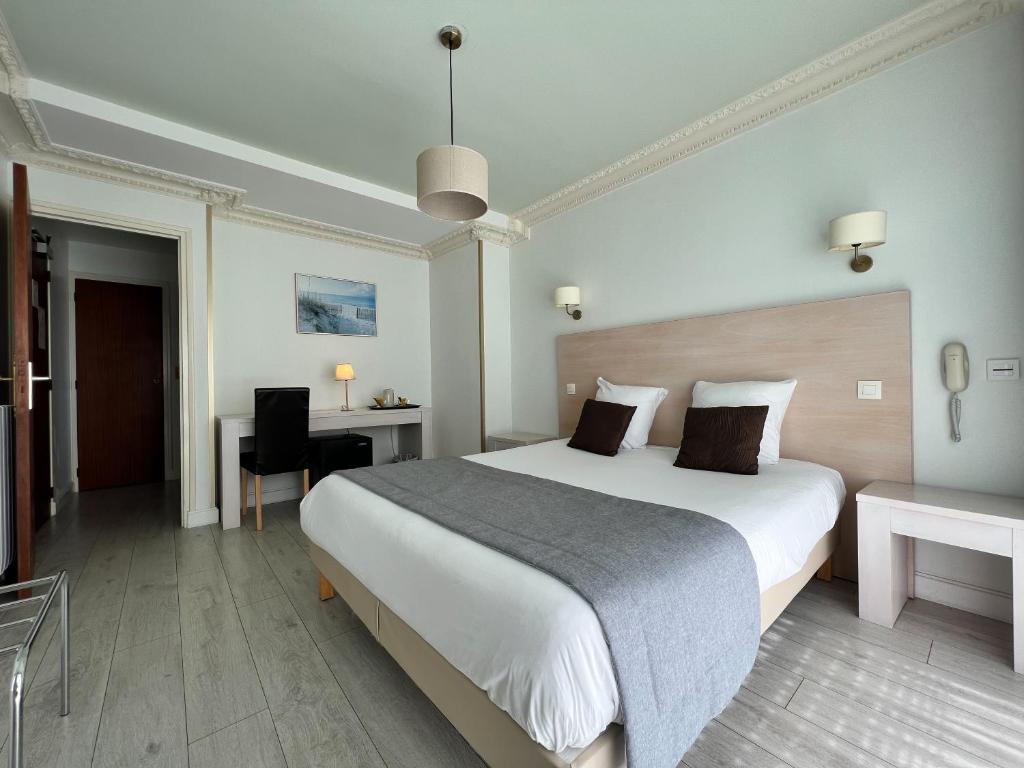 a hotel room with a large bed and a desk at Hôtel Ker-Noyal Quiberon Plage in Quiberon