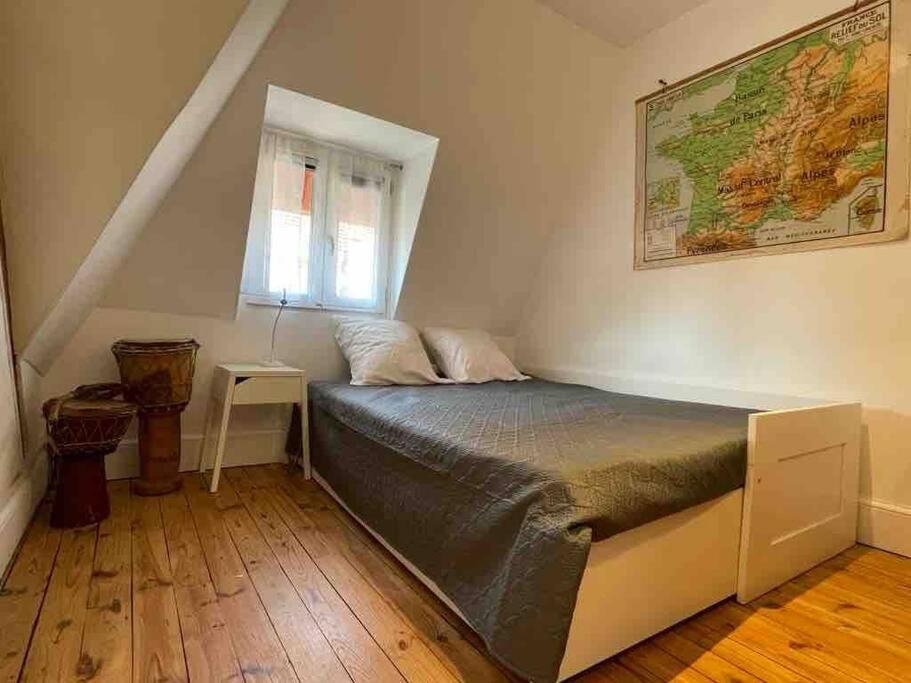ein Schlafzimmer mit einem Bett und einer Karte an der Wand in der Unterkunft Maison de caractère en centre ville in Vichy
