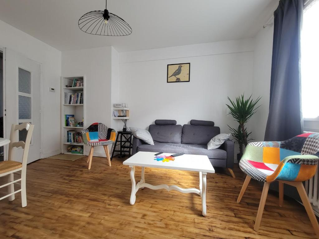 uma sala de estar com um sofá e uma mesa em Ker Armand, appartement Thabor proche hyper centre em Rennes