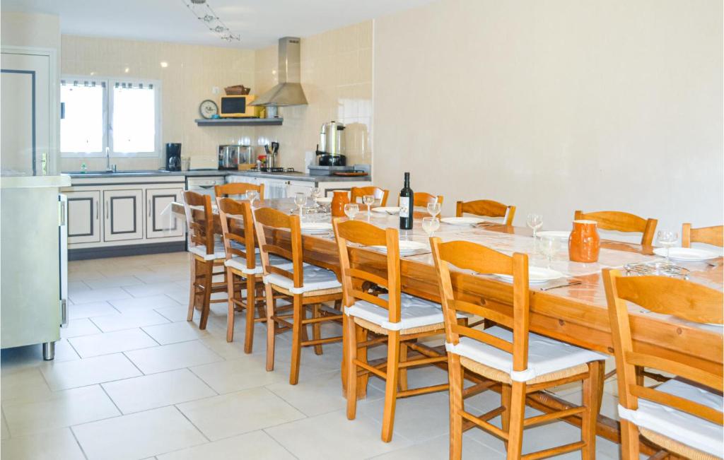 kuchnia z długim drewnianym stołem i krzesłami w obiekcie 4 Bedroom Cozy Home In La Douze w mieście La Douze
