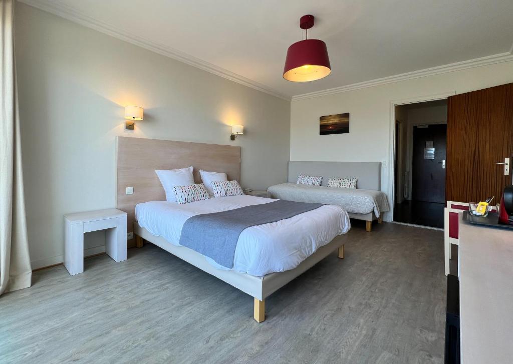 a bedroom with two beds and a red light at Hôtel Ker-Noyal Quiberon Plage in Quiberon