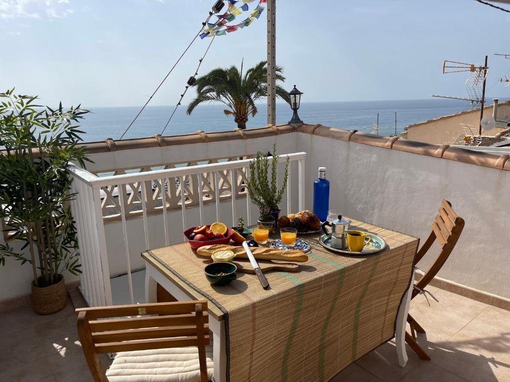 a table with food on a balcony with the ocean at Oldtown family house with amazing terrace - 3 minutes from beach! in Villajoyosa