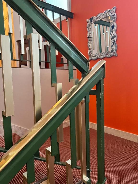 a staircase with green railings and a mirror on the wall at Hôtel Ker-Noyal Quiberon Plage in Quiberon