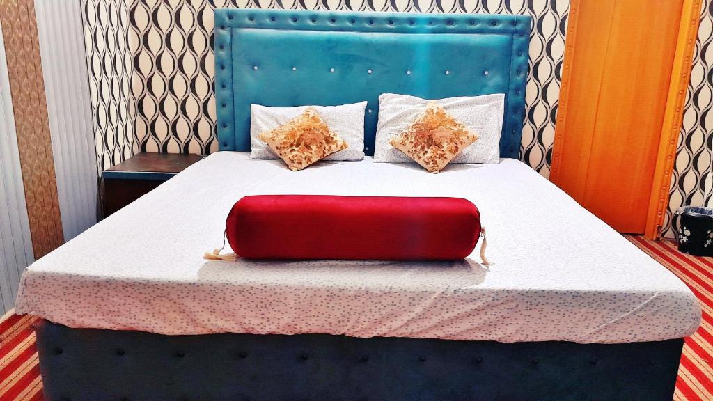 a red suitcase is sitting on a bed at Hotel Super Seven in Lahore