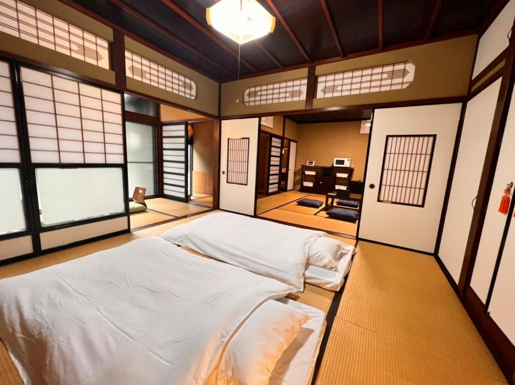 um quarto com 2 camas num quarto com janelas em あざみ庵山中温泉 em Kaga