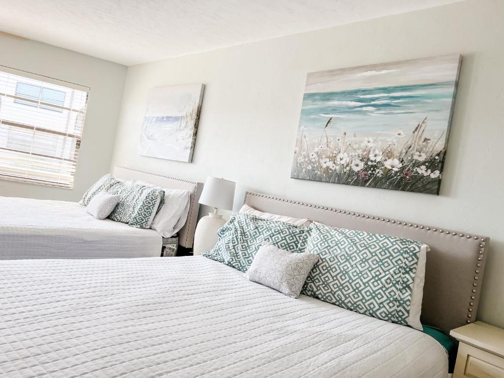 a bedroom with two beds and a couch at Knot a Care Remodeled Direct water access condo with ocean and pool views NOW SLEEPS SIX in Marco Island