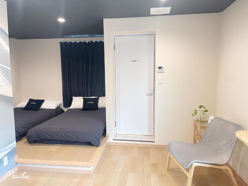 Un dormitorio con una cama y una silla dentro. en Leisure hotel 中野, en Tokio
