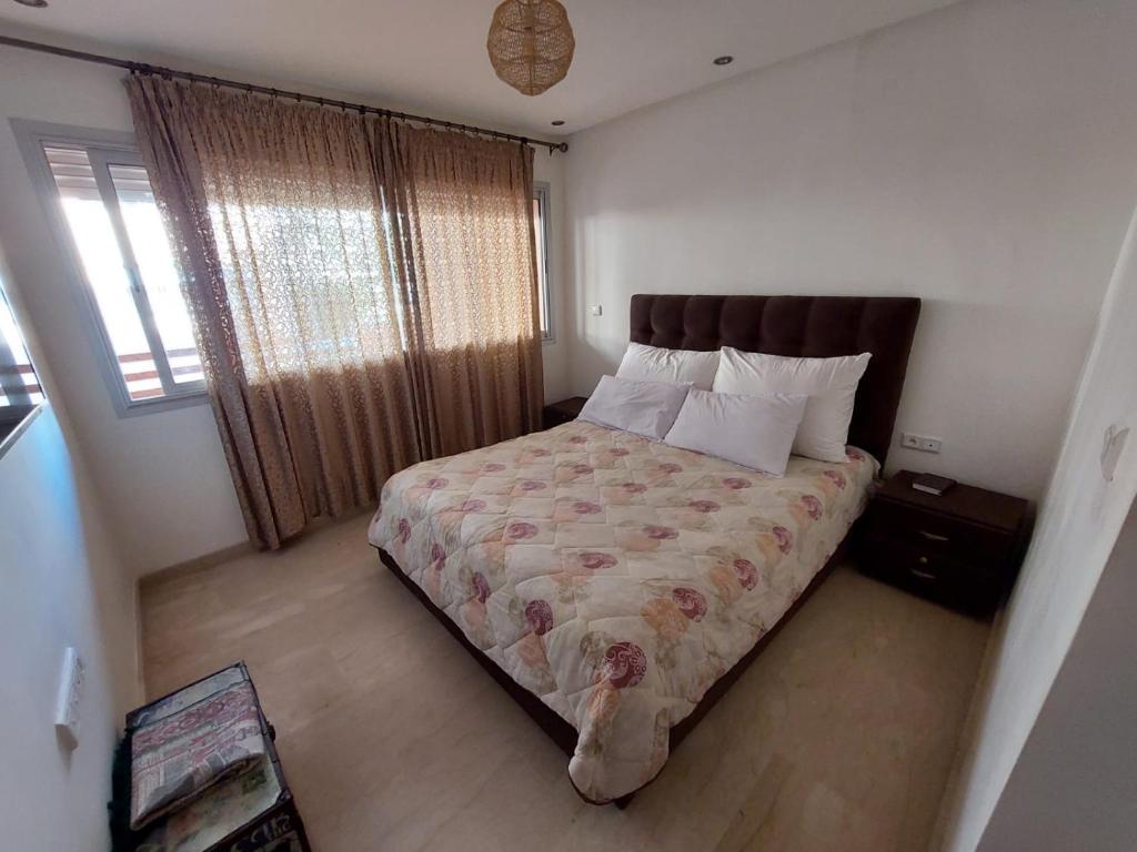a bedroom with a bed and a window at Appartement pied dans l'eau imi Ouaddar in Imi Ouaddar