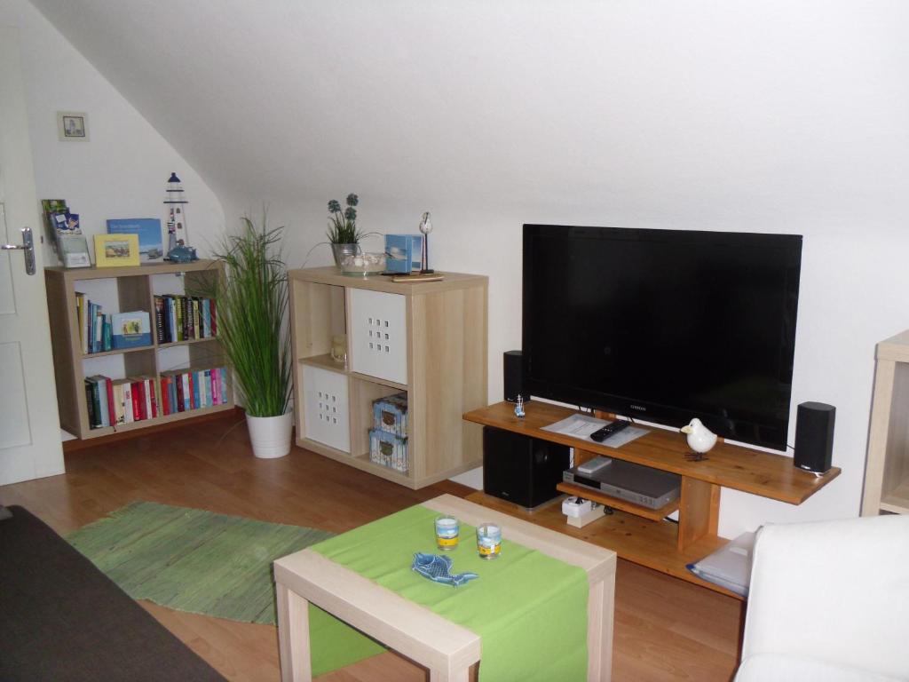 een woonkamer met een grote flatscreen-tv bij Ferienwohnung Lachmöwe in Heringsdorf