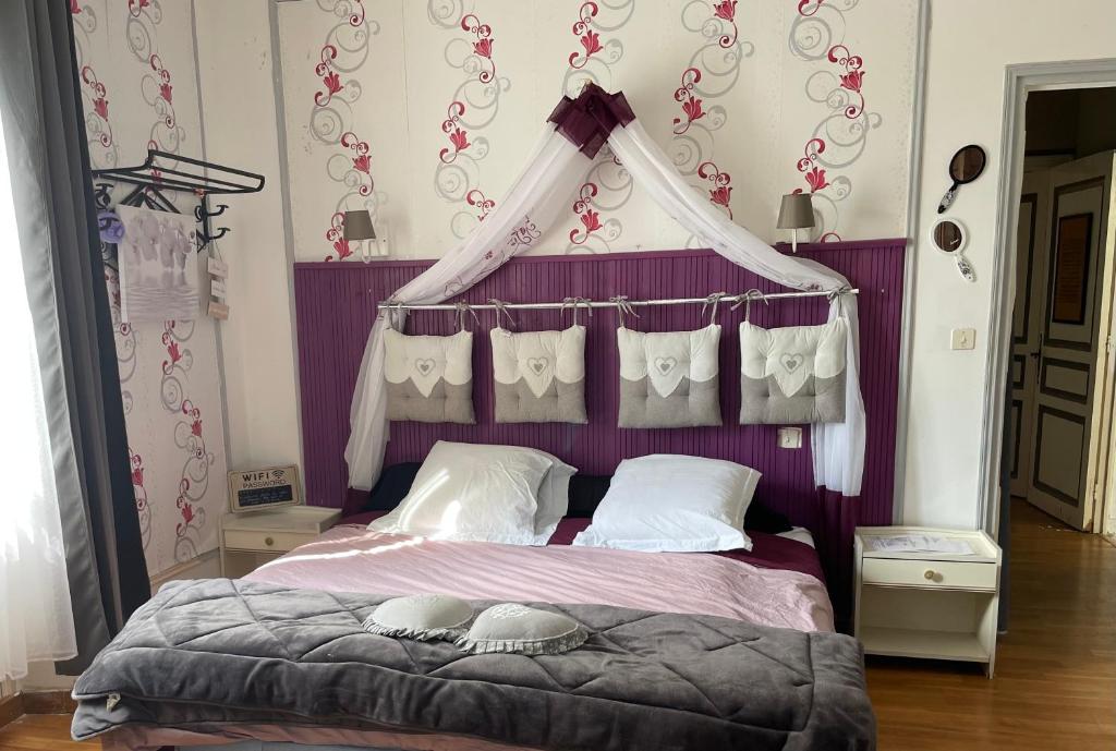 Labastide-MuratにあるLes chambres de cathyのベッドルーム(天蓋付きの紫色のベッド1台付)