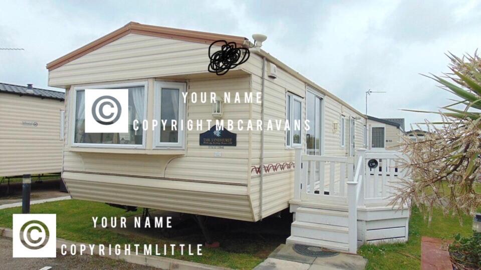 a white mobile home with a sign on it at Goldensands in Foryd