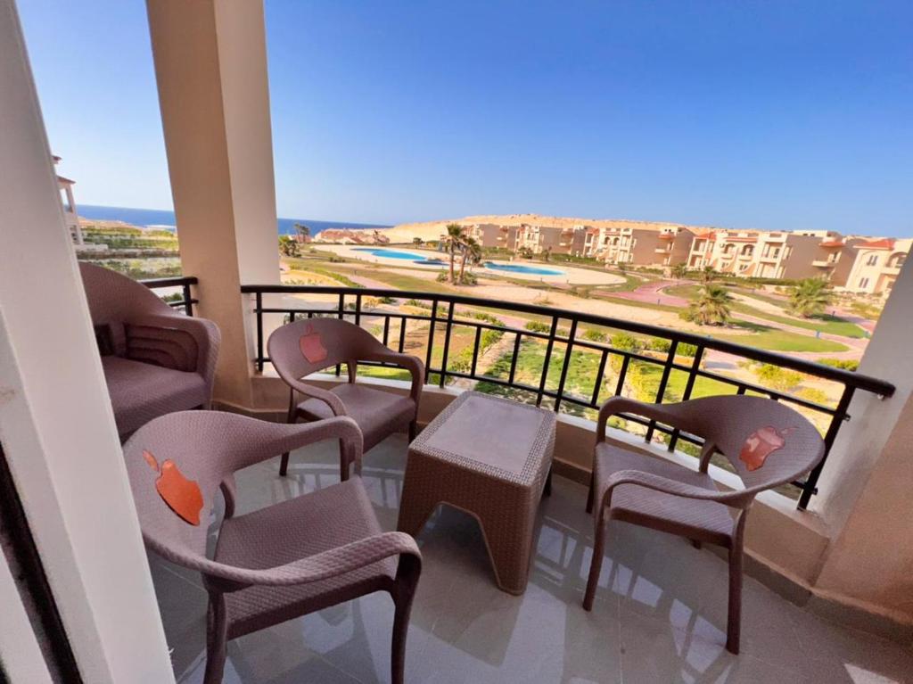 a balcony with chairs and a table and a view at Coral hills North Coast كورال هيلز الساحل الشمالي in El Dab‘a