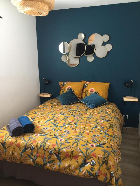 - une chambre avec un lit, une couette colorée et des miroirs dans l'établissement Le Georges, à Aiguilhe