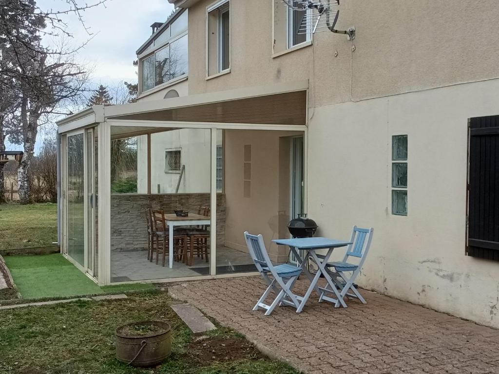 eine Terrasse mit Stühlen und einem Tisch vor einem Haus in der Unterkunft Entre Puy-de-Dôme et Corrèze Appartement pour 4 personnes avec terrasse et jardin in Monestier-Merlines
