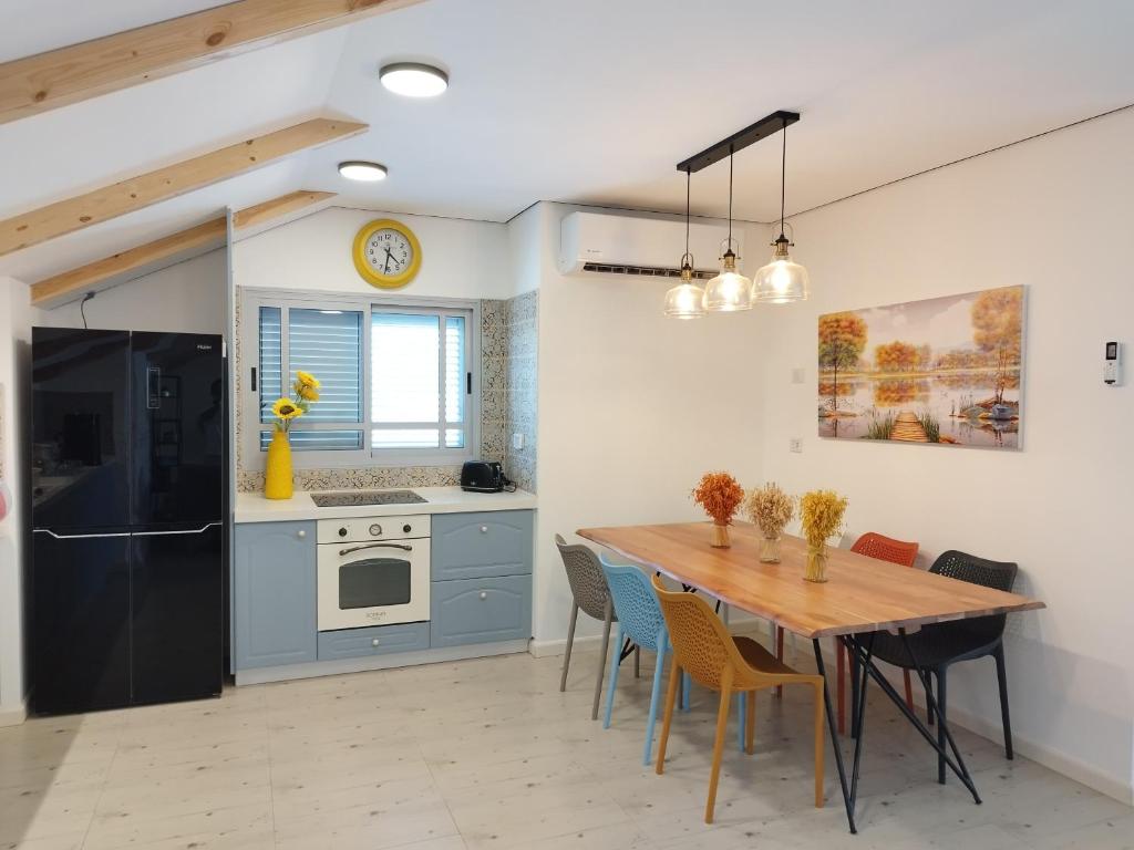a kitchen with a wooden table and a dining room at סוויטת בוטיק in Netivot