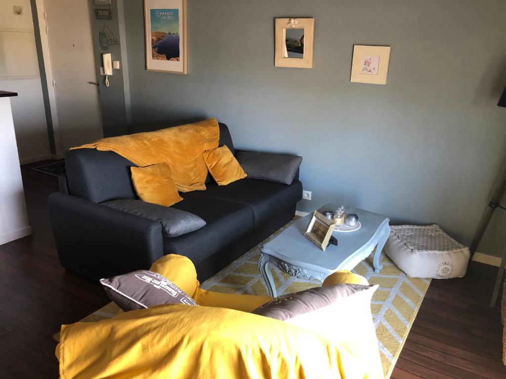 ein Wohnzimmer mit einem Sofa und einem Tisch in der Unterkunft LISACA in Camaret-sur-Mer