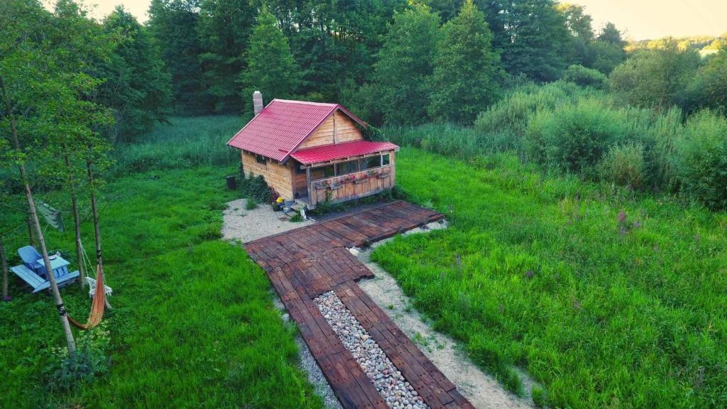 ein kleines Gebäude mit rotem Dach auf einem Feld in der Unterkunft Sowia Chatka in Glaznoty