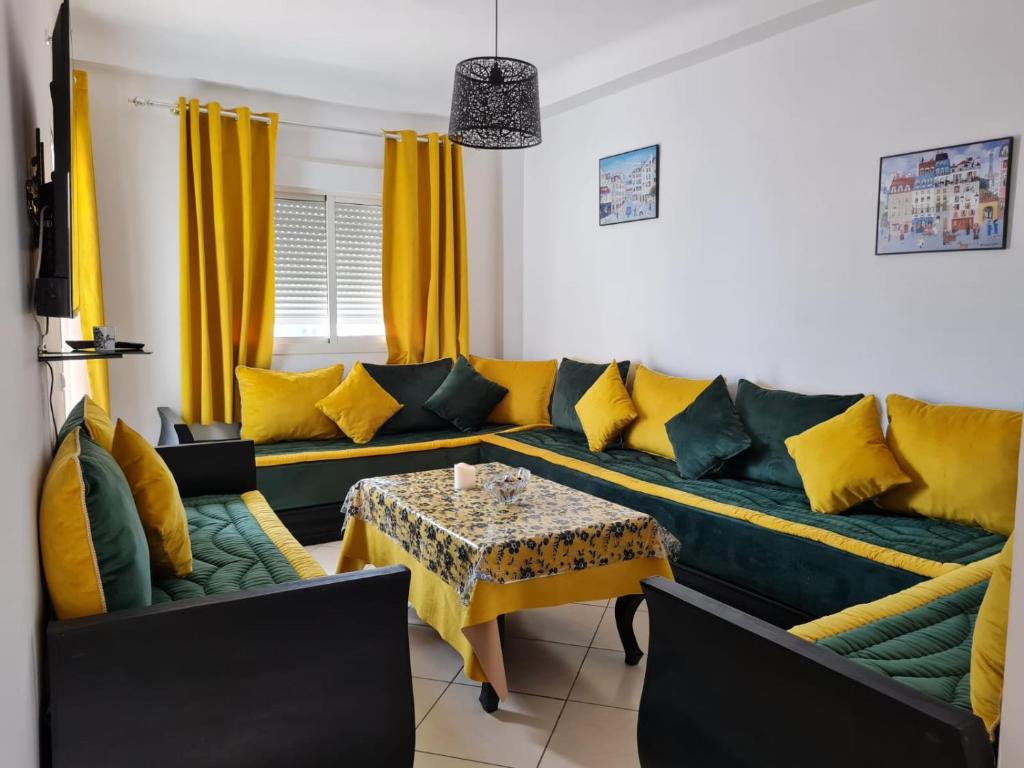 a living room with a couch and a table at NRY Home magnifique Appartement , prêt de plage in Martil