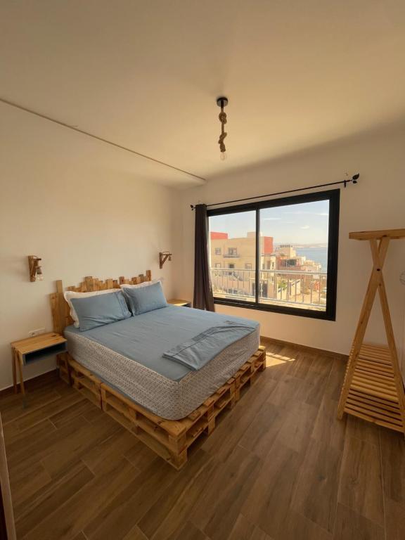 1 dormitorio con cama y ventana grande en Moon Surf en Imsouane