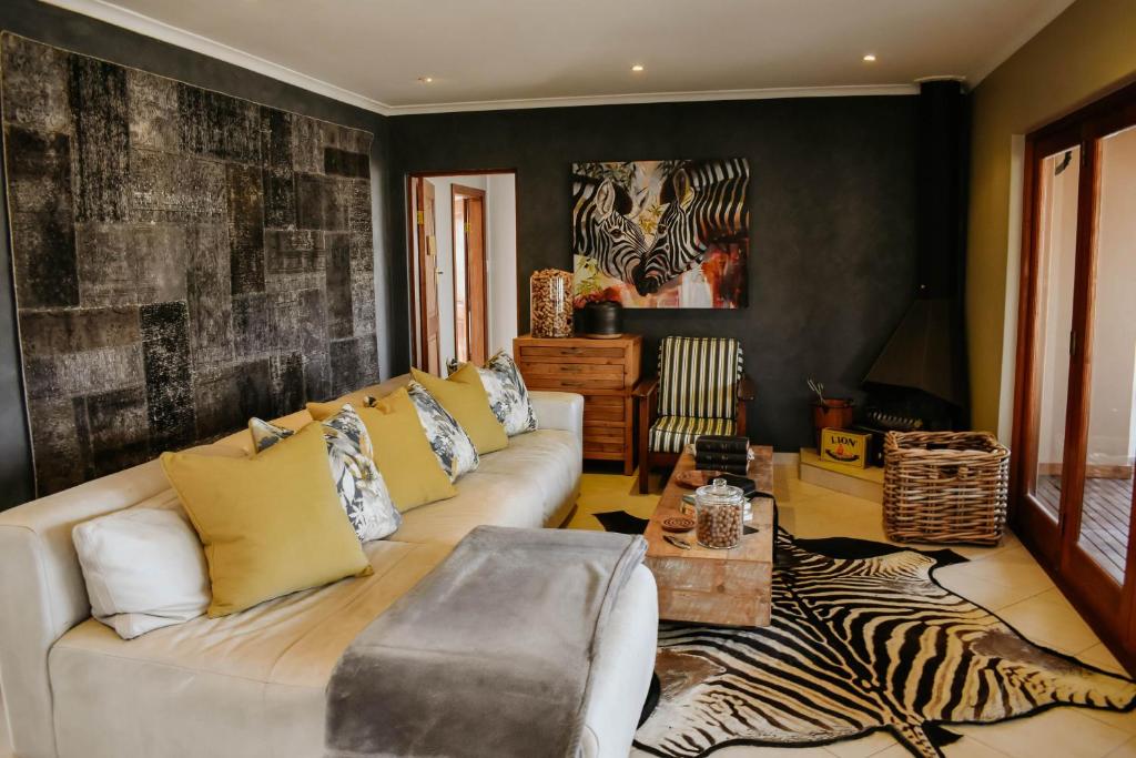 a living room with a couch and a zebra rug at Cwebile Guesthouse in Winterton